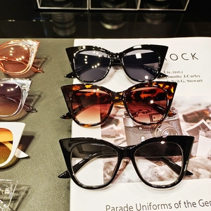 Dettaglio di occhiali da sole cat-eye in nero, bianco e tartarugato di tendenza