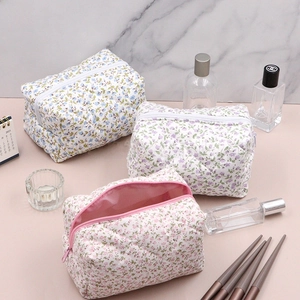 Detailed view of quilted floral cosmetic bags in three colors with spacious zipper interior