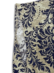 Detailed close-up of navy blue floral print and neat overlock stitching on the dress fabric