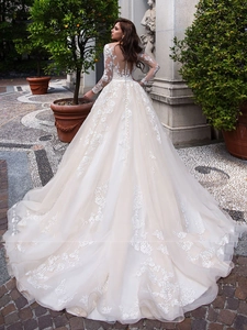 Detailed back view of a long-sleeved lace wedding dress with an elegant long train and buttons