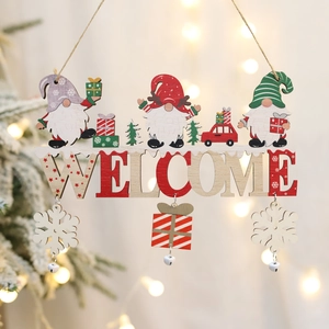 Wooden Christmas gnome welcome sign hanging decoration with holiday tree lights background