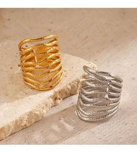 Close-up of gold and silver multi-layer rings with hammered texture on a natural stone base