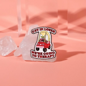 Detail of a pink car enamel pin with Get In Loser and therapy text on crystal props