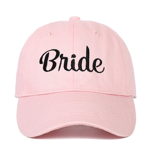 Close-up of pink baseball cap featuring black Bride script embroidery on cotton fabric