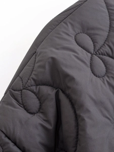 Detail of dark gray quilted jacket showing wave stitching and synthetic fabric texture