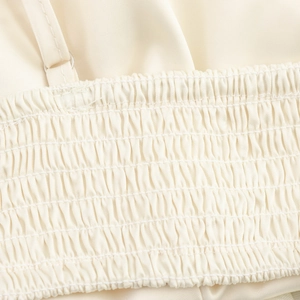 Close-up of beige 3D floral camisole top featuring elastic smocked fabric texture