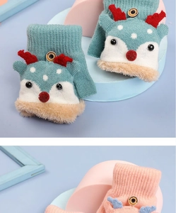 Detail of green and pink knit reindeer gloves with soft faux fur trim and cute antlers