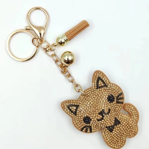 Cartoon kitten rhinestone keychain with golden bell and leather tassel on white background