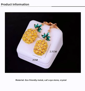 Close-up of pineapple keychain with yellow cat eye stone and green crystal leaf details