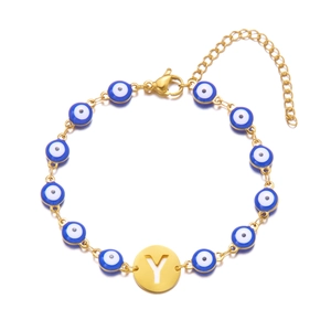 Detailed macro view of gold evil eye bracelet featuring letter Y hollow charm and lobster clasp