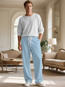 Close-up of light blue waffle knit pants featuring a white drawstring and texture