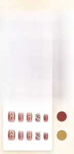 Détail de faux ongles dégradés roses avec strass brillants et breloques dorées géométriques