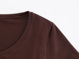 Detail of deep brown U-neck stitching and shoulder seam on a fitted cotton t-shirt