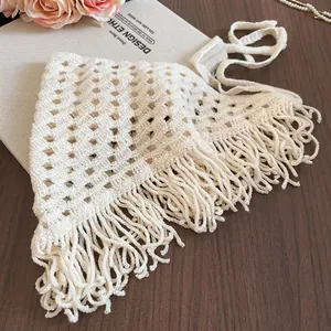 Handcrafted cream crochet triangle bandana with long fringe on a rustic wooden background