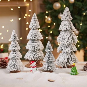Miniature white flocked cedar trees with wooden bases and snowy Christmas decor accents