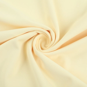 Detail of soft beige ruffled knit fabric showing fine texture and elegant drape
