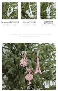 Glittery Christmas ornaments featuring musical instruments and Eiffel Tower on tree