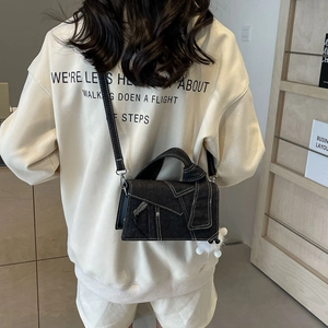 Sac bandoulière en jean structuré avec coutures blanches et breloque boule en peluche