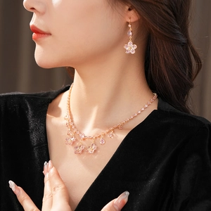 Detail of pink crystal cherry blossom necklace and drop earrings on a model
