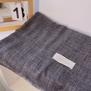 Close-up of dark grey cotton linen scarf with fringe edges and autumn fashion studio label