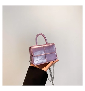 Macro view of metallic purple crocodile pattern mini bag with silver chain and top handle