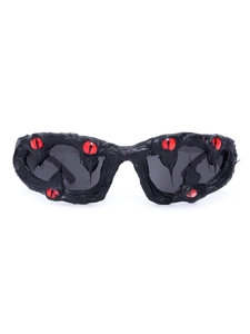 Close-up of black street style sunglasses with red bionic eye accents and grey lenses