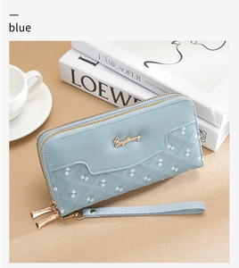 Detail of light blue floral patchwork wallet with double zipper and wrist strap