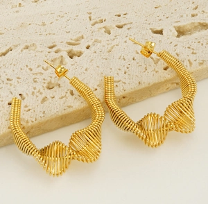 Detailed macro view of spiral wire textures on golden stainless steel spring earrings