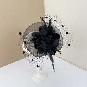 Close-up of a vintage black fascinator with floral net veil and feather detail