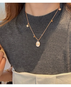 Détail du collier en nacre plaqué or 18 carats avec étoiles porté par une femme