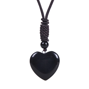 Detailed close-up of heart-shaped black obsidian pendant with adjustable woven cord