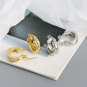 Detailed view of silver and gold S925 sterling silver crossover hoop earrings