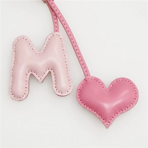 Pink leather M-letter and heart bag charm with elegant white hand-stitched details