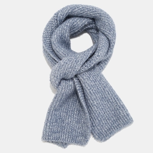 Detailed view of light blue cable knit scarf with soft thick texture and woven pattern