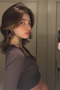 Gros plan d'une boucle d'oreille vintage étoilée avec gemmes rouges portée par un mannequin