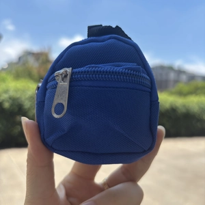Mini navy blue canvas backpack coin purse held in hand with clear zipper detail