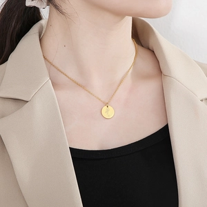 Gros plan d'un collier avec pendentif fleur de naissance en acier doré sur un mannequin