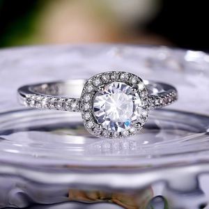 Macro shot of silver halo ring featuring a round brilliant center stone and micro-pave band