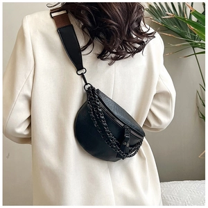 Close-up of black crocodile pattern belt bag with metal chain and two-tone strap