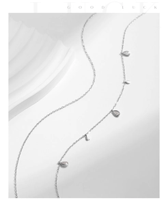 Détail d'un collier double épaisseur en argent avec pendentifs moissanite en goutte