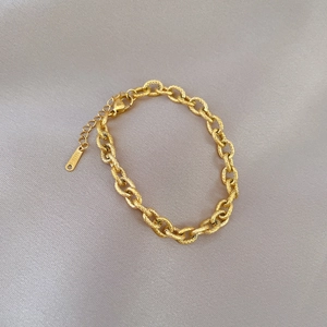 Detail view of gold titanium steel link bracelet with lobster clasp and S.STEEL charm