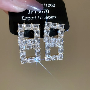 Detail of 18K gold plated hollow square earrings with shimmering cubic zirconia
