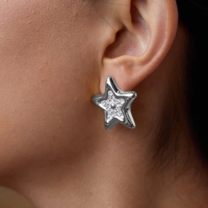Gros plan de la boucle d'oreille étoile argentée bombée sertie de strass brillants