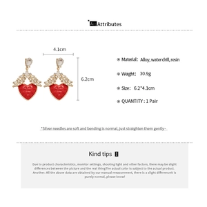 Détail des boucles d'oreilles cœur rouge montrant les dimensions 6,2 cm par 4,1 cm