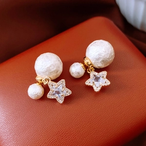 Detail of 18K gold-plated star pearl earrings featuring unique textured cotton pearls