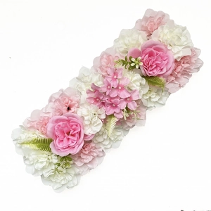 Macro shot of artificial silk wedding flower row with pink and white roses and hydrangeas
