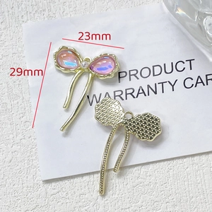 Détail du pendentif nœud rose iridescent 23x29mm avec perle pour bijoux DIY