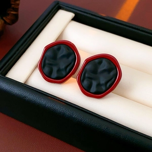Vue macro de boucles d'oreilles hexagonales avec texture mate rouge et noire