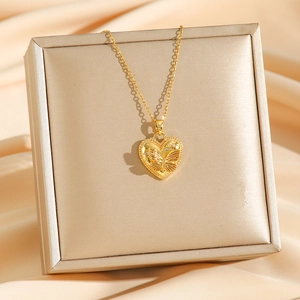 Elegante collana con ciondolo a cuore dorato e farfalla in rilievo su portagioie oro