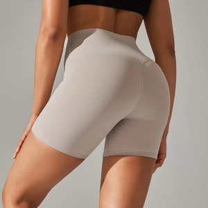Close-up of high-waisted yoga shorts in grey showing peach lift and seamless fit